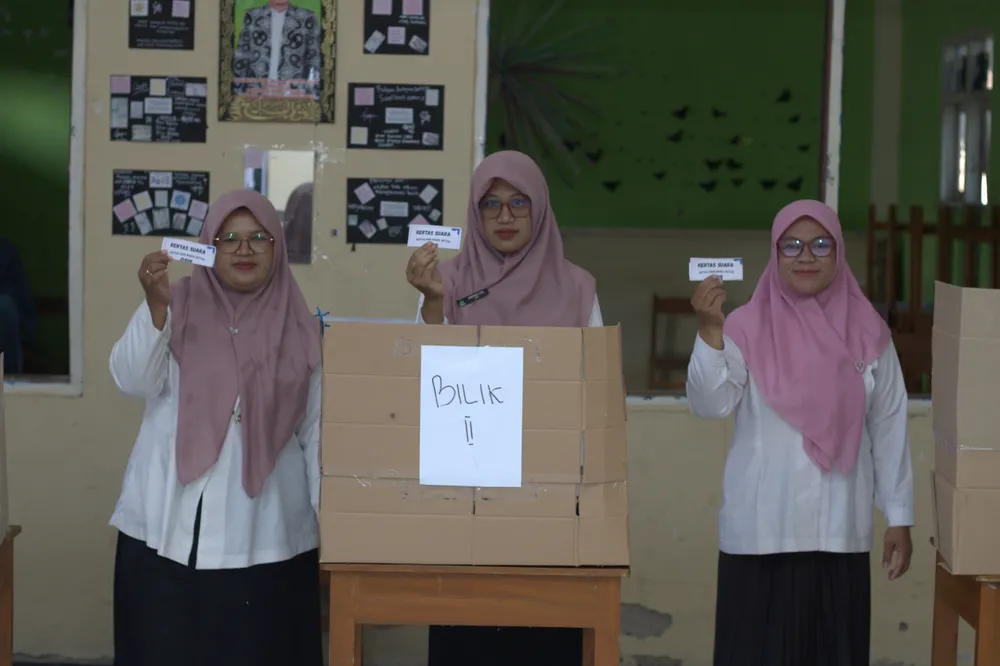 Guru memperlihatkan surat suara dalam rangkaian pemilihan OSIS